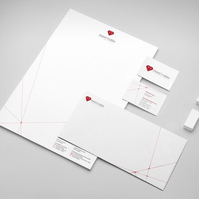 Bild vergrößern: Auf einem Tisch liegen ausgebreitet Briefbogen, Briefumschlag und Visitenkarte eines Unternehmens mit Logo im Aussehen eines Rubins.
